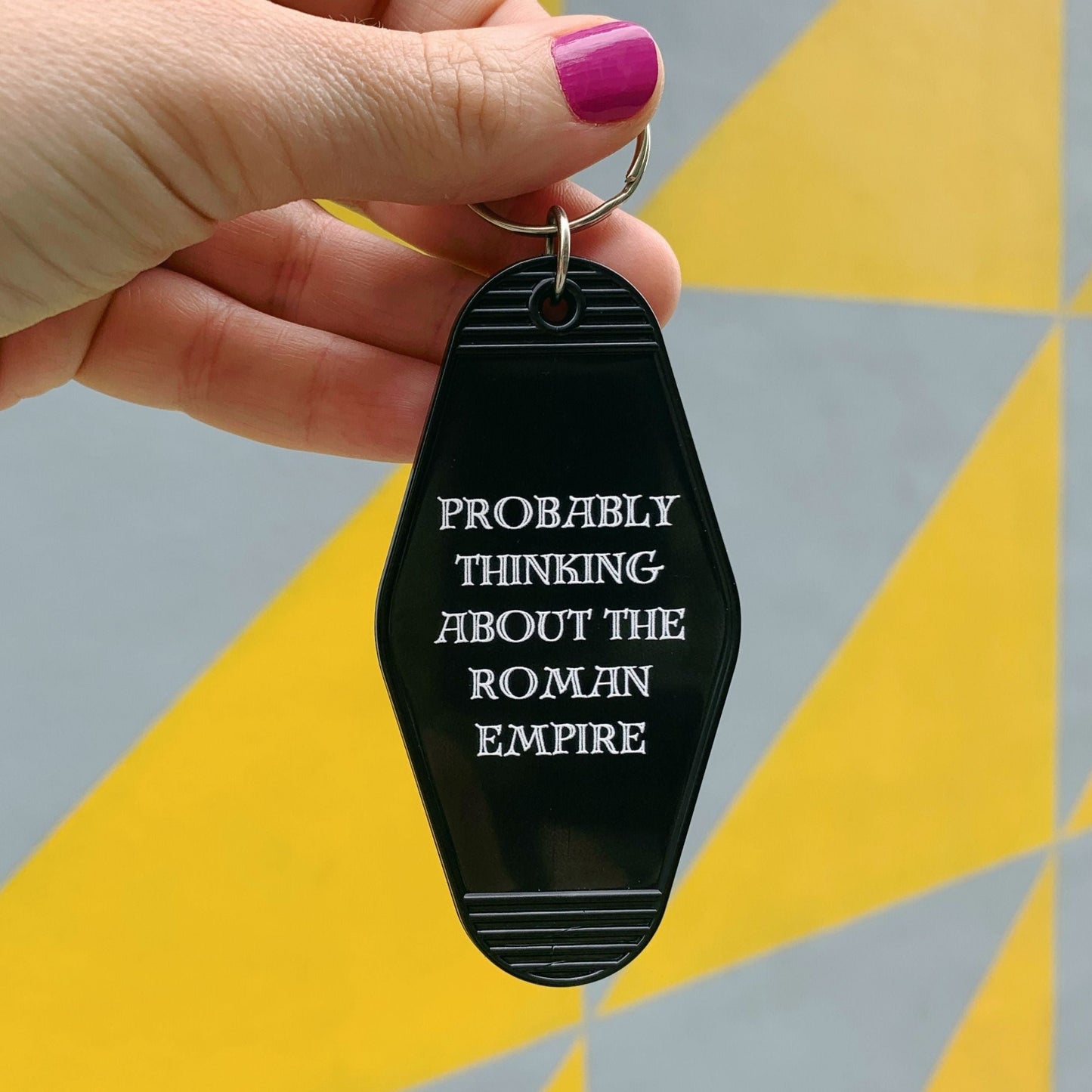 Probably Thinking About the Roman Empire Motel Style Keychain in Black by The Bullish Store