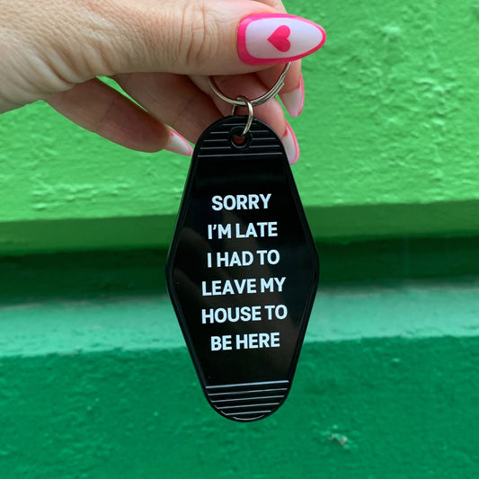 Sorry I’m Late I Had to Leave My House Motel Style Keychain in Black by The Bullish Store