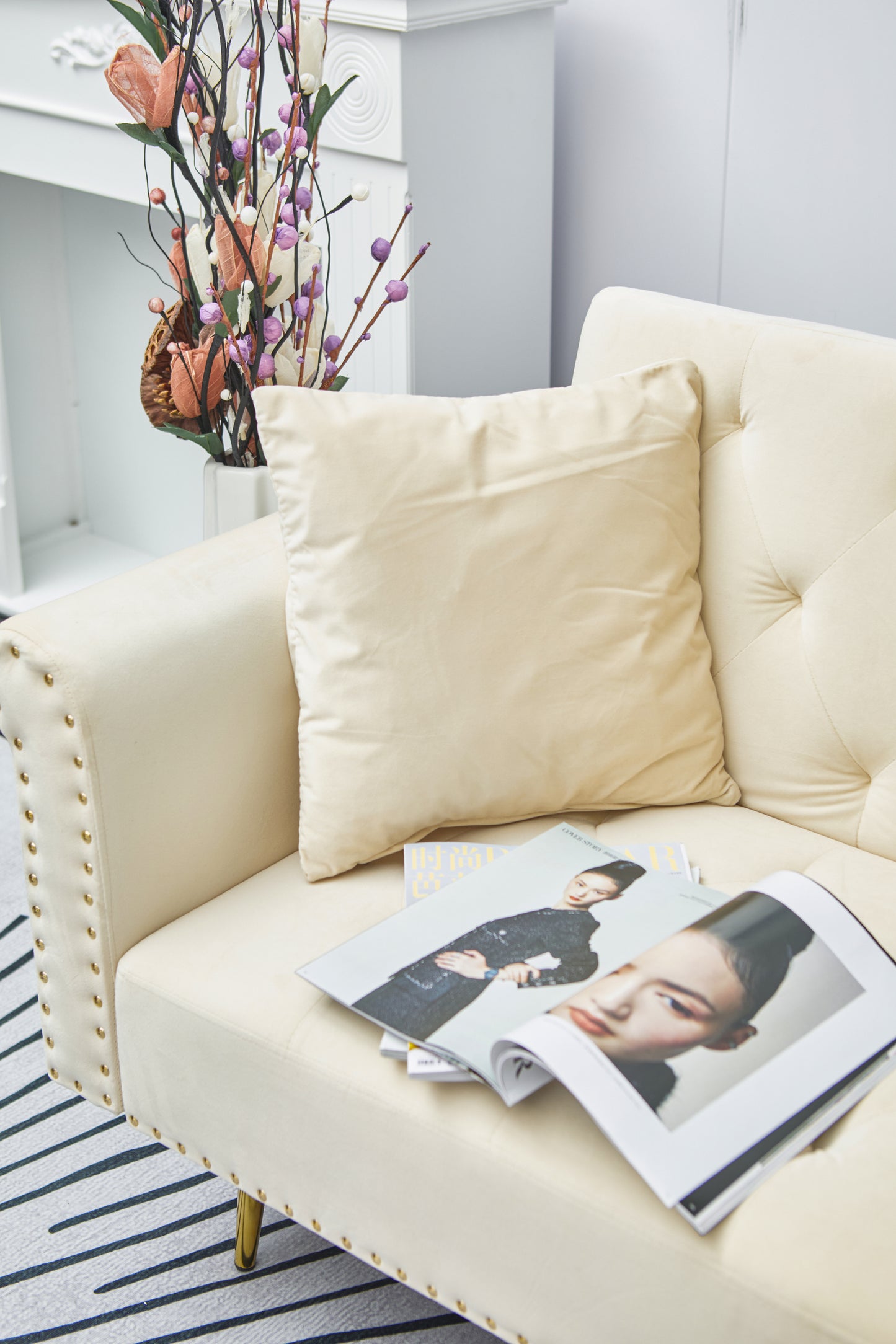 Beige velvet nail head sofa bed with throw pillow and midfoot